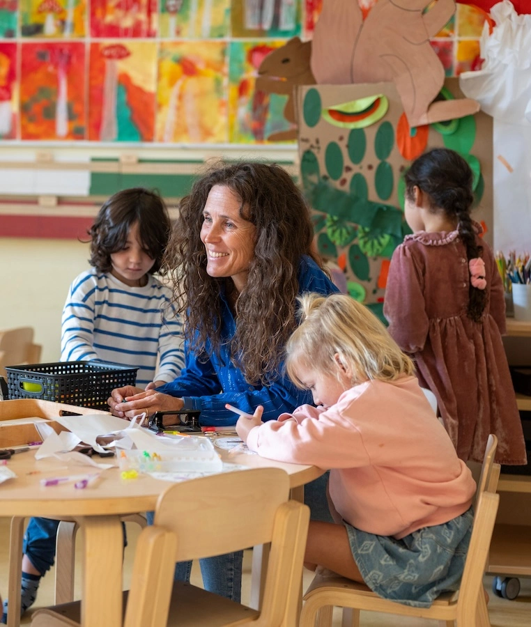 Kindererzieherinnen in einem Raum mit Kindern.